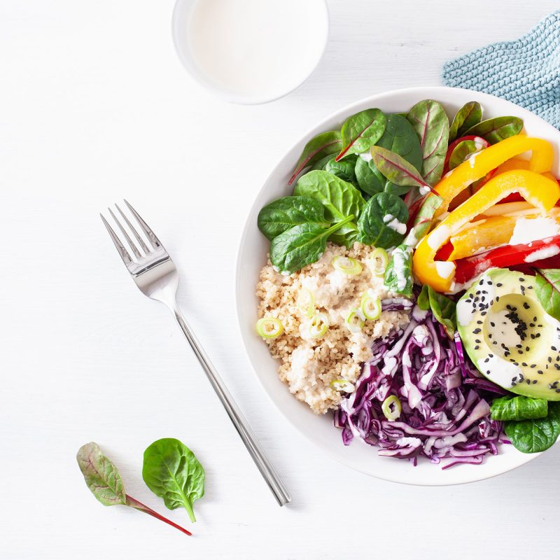Una ciotola di verdure colorate e riso, accompagnata da una forchetta, rappresenta un pasto sano e nutriente